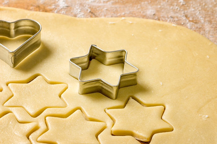 Rolled out cookie dough with star and heart cookie cutters - making cookies