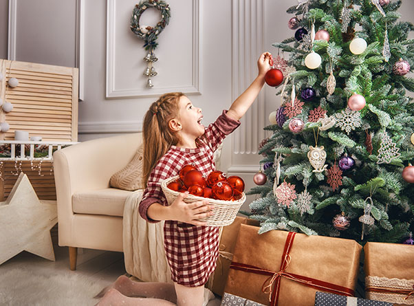 A little girl decorating the Christmas tree