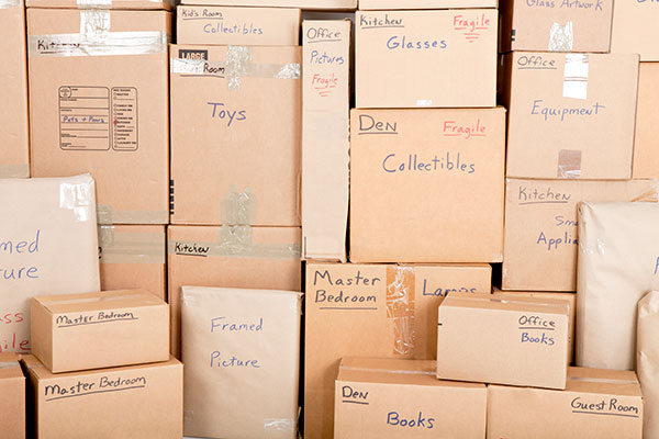 Dozens of cardboard boxes stacked and handwritten labeled and ready to be moved or stored