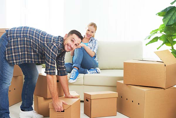 Young couple packing boxes in their living room.