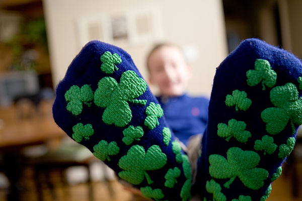 A kid wearing shamrock socks for St. Patrick's Day