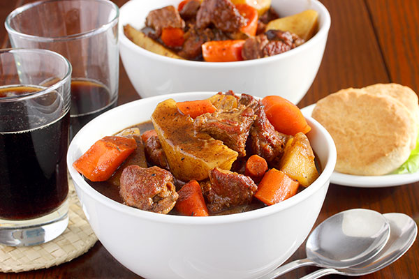 Two bowls of Irish lamb stew with dark soda on St. Patrick's Day