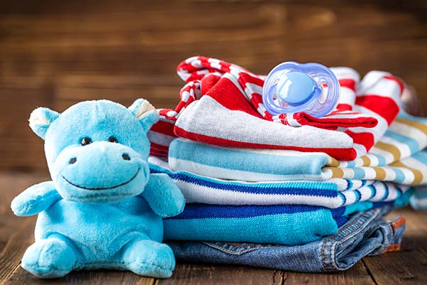 Baby's stuffed animal, folded clothes and pacifier.