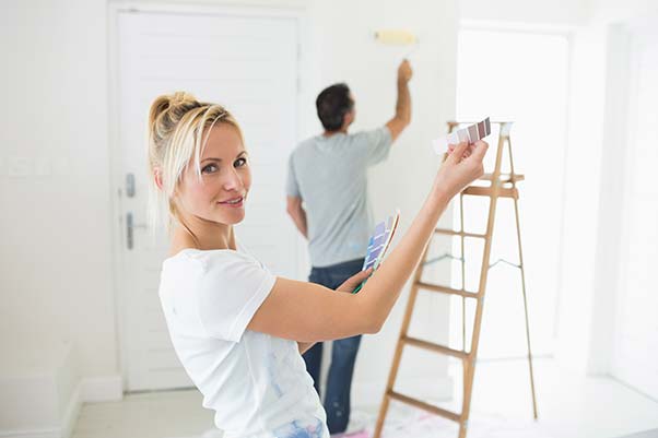 A young couple painting the interior of their house