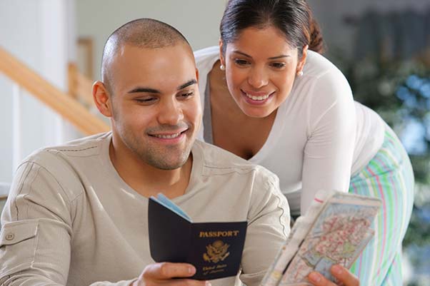 A couple checking their passport and looking at a map getting ready for vacation.