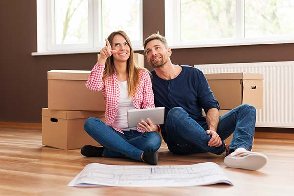 A couple looking at floor plans in their new home