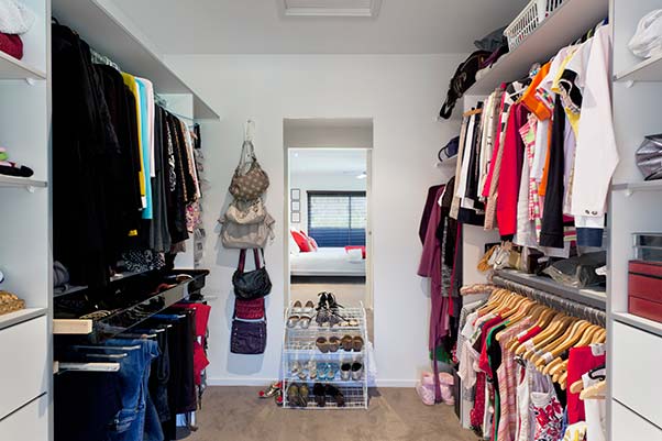 A modern his and hers walk-in closet complete with shoe racks.