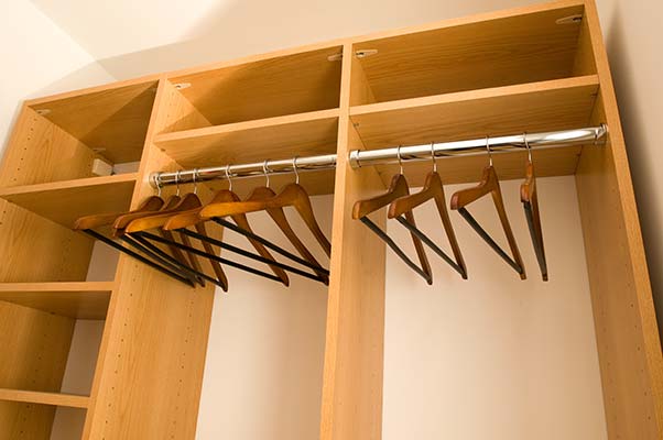 A closet organizing system with shelves and hangers.