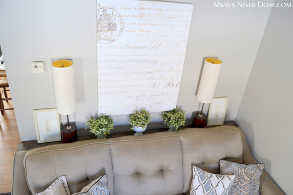 A skinny table set behind a sofa with photos and decor to save space.