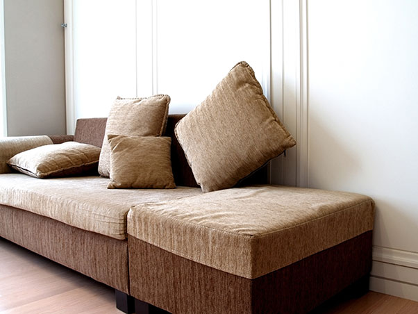 Brown sofa bed converted for sleeping.