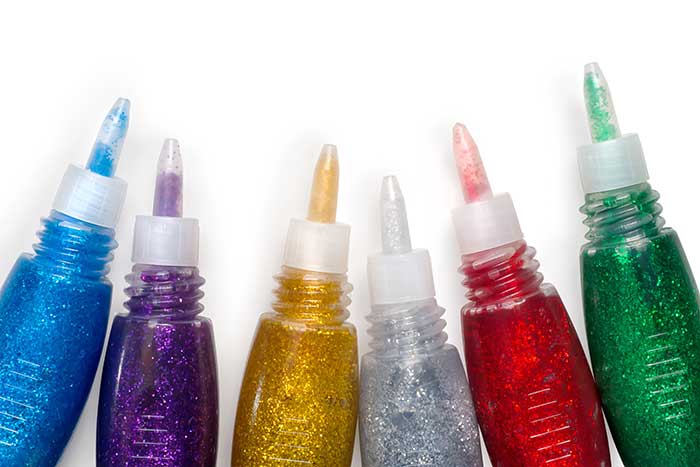 Blue, purple, gold, silver, red and green glitter glue bottles for crafting