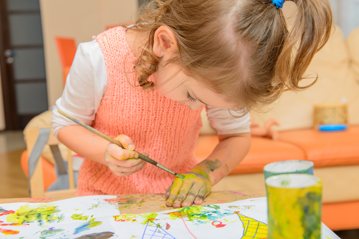 Young girl painting her hand