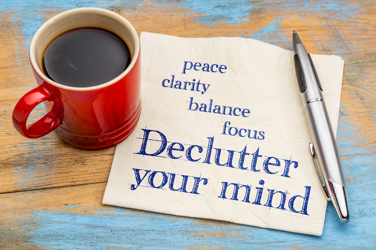 Declutter your mind for clarity, peace, focus and balance - handwriting on a napkin with a cup of espresso coffee