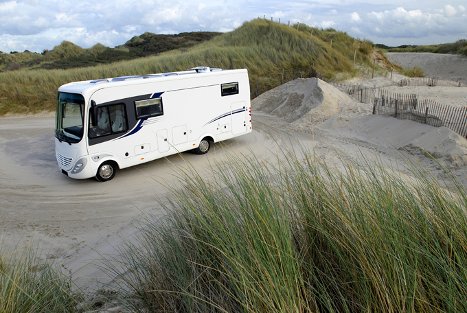 White RV parked near sand dunes