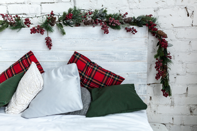 Bed with Christmas garland over headboard