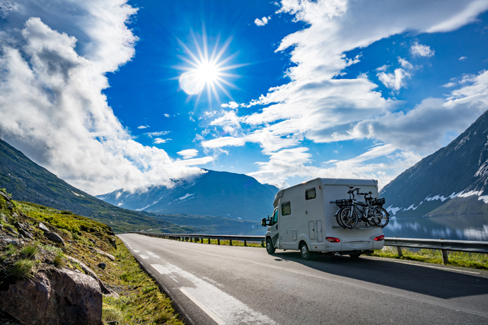 RV driving down the road on a sunny day