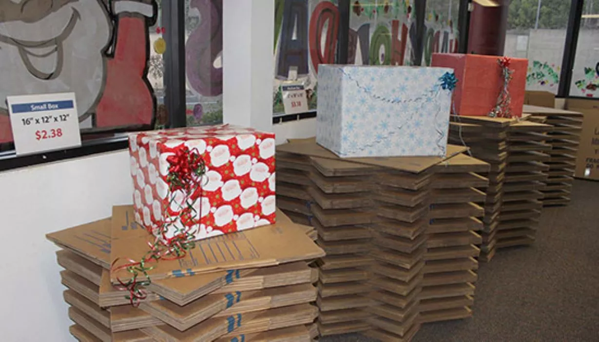 Box displays wrapped in Christmas wrap for holiday gift wrapping station inside the office