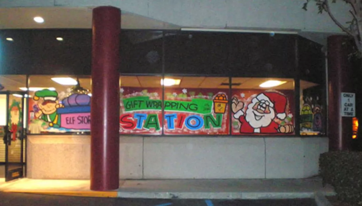 Windows and doors painted with elf and Santa Claus holiday theme for gift wrapping station