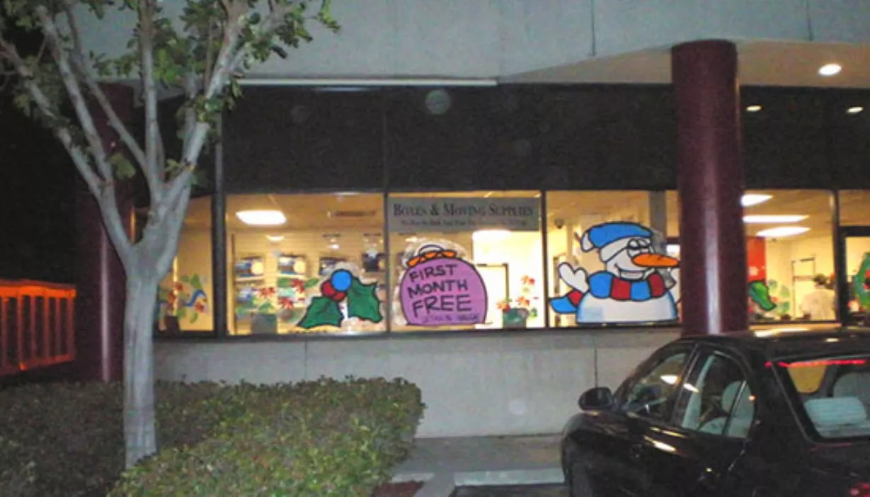 Rental office windows painted with holiday theme and first month's rent free promotion