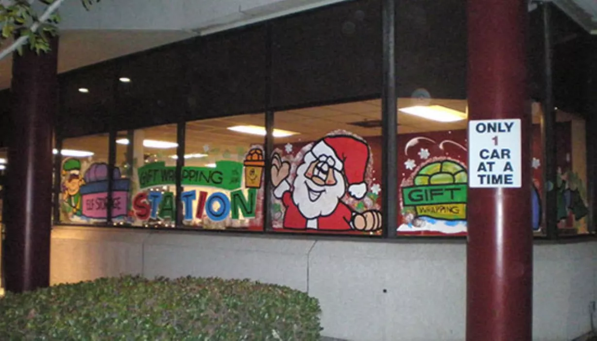 Rental office holiday themed painted windows for gift wrapping station