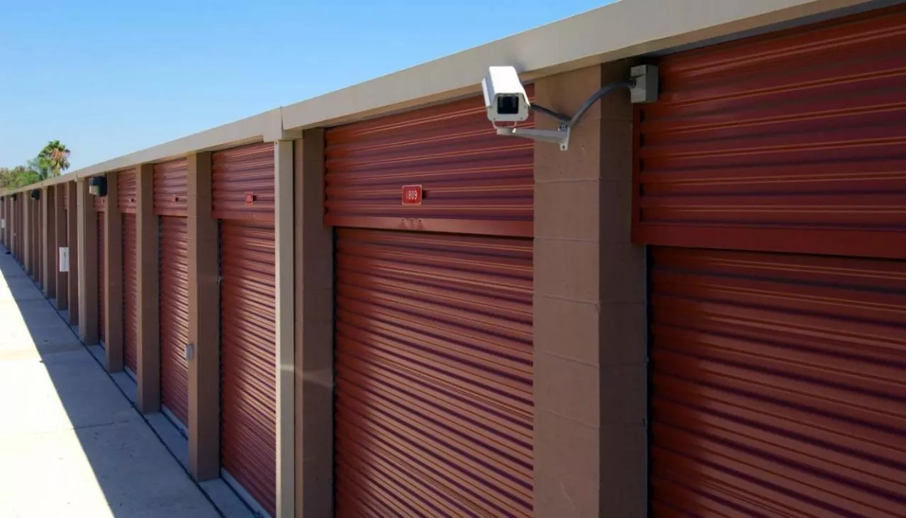 Very large drive up storage units with roll up doors and security camera on the building
