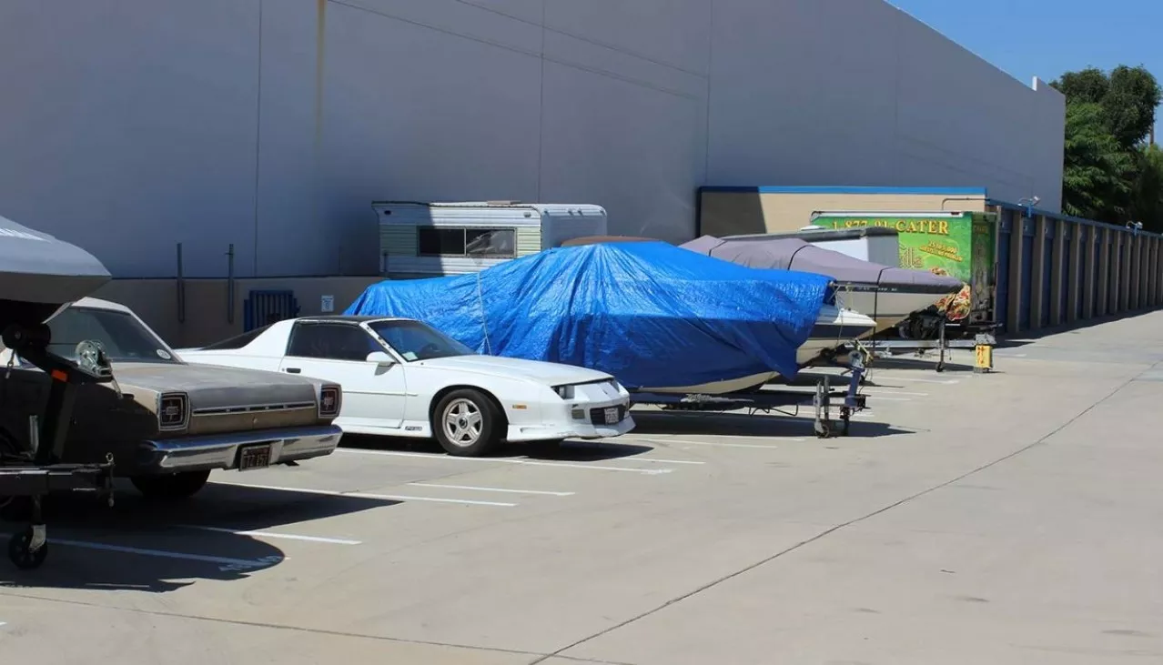 Boat, cars and trailer parked in the outdoor vehicle storage 