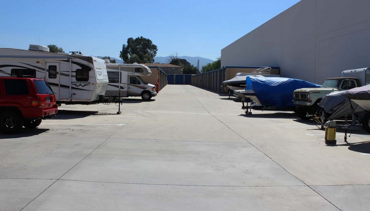 Boats, cars, RVs, and trailers parked in the outdoor vehicle storage area
