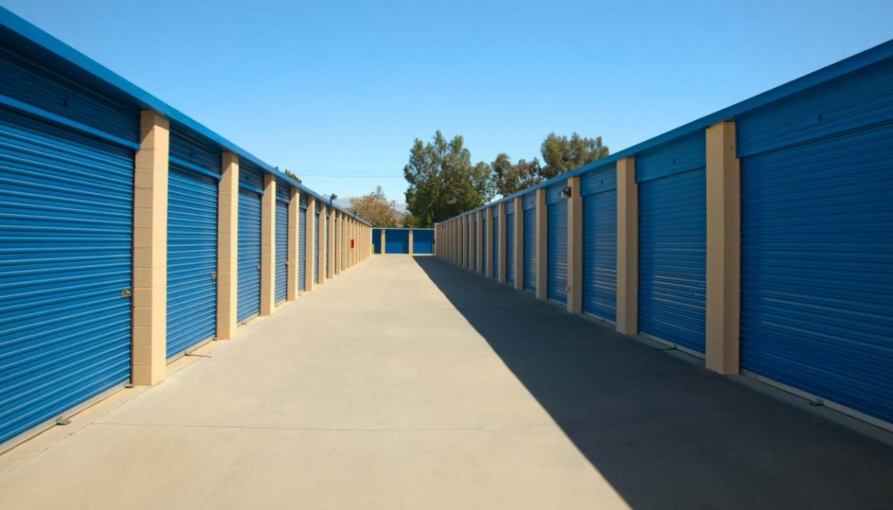 Wide drive aisle of drive up storage units with metal roll up
