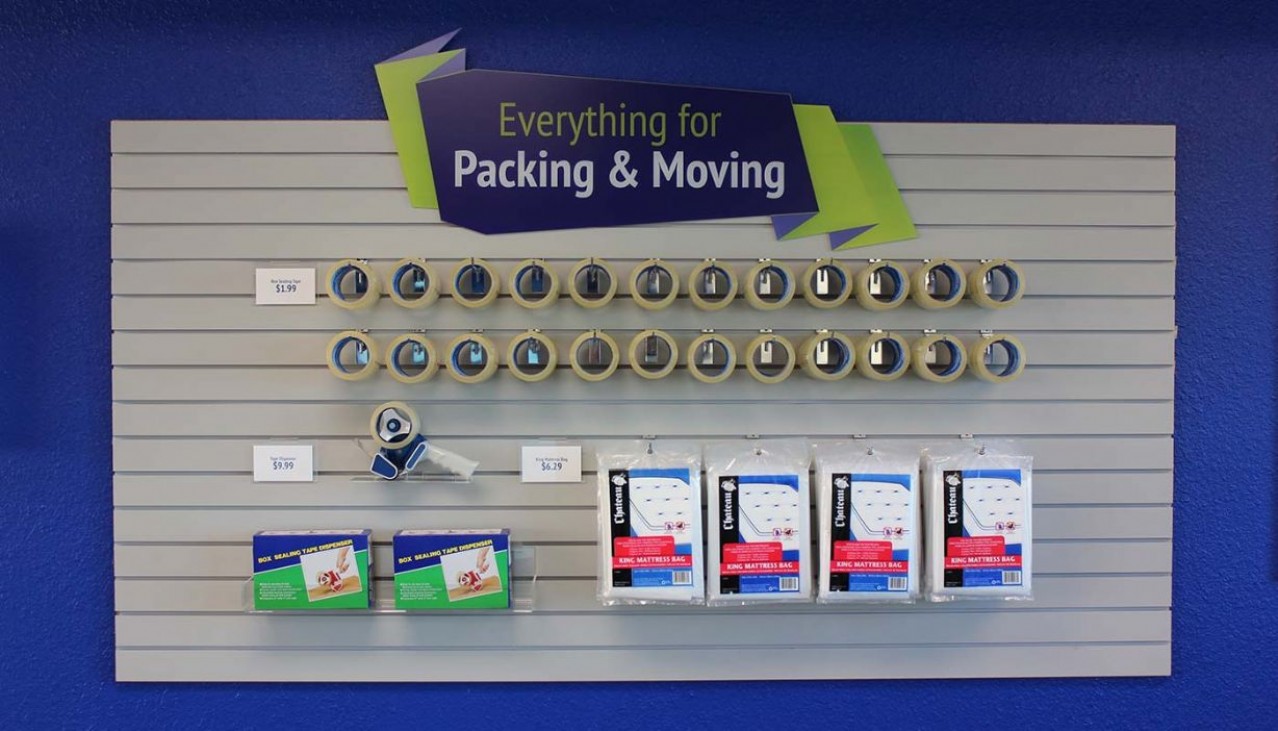 Price Self Storage Pacific Beach rental office packing supplies; tape, bubble wrap, mattress bag on merchandise display wall