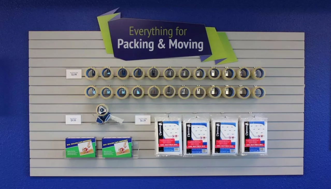 Price Self Storage Pacific Beach rental office packing supplies; tape, bubble wrap, mattress bag on merchandise display wall