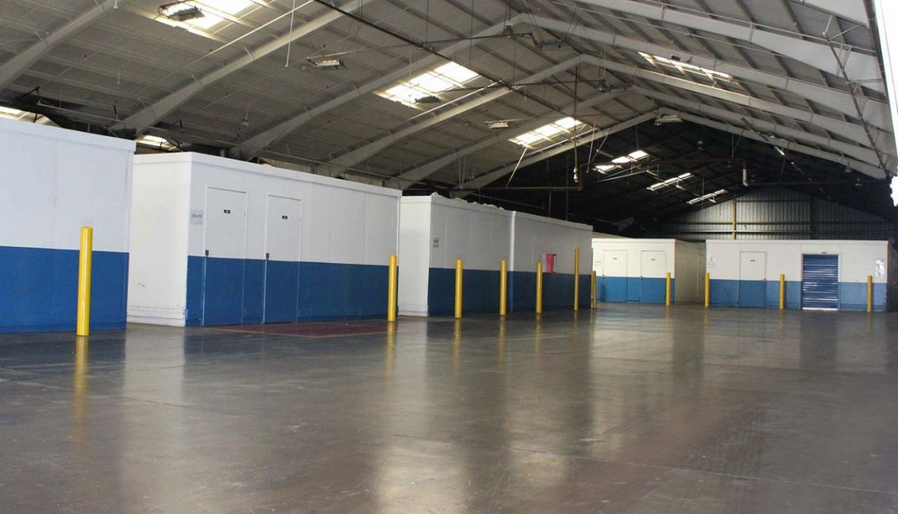 Storage facility hallway with variety of storage units with roll up doors