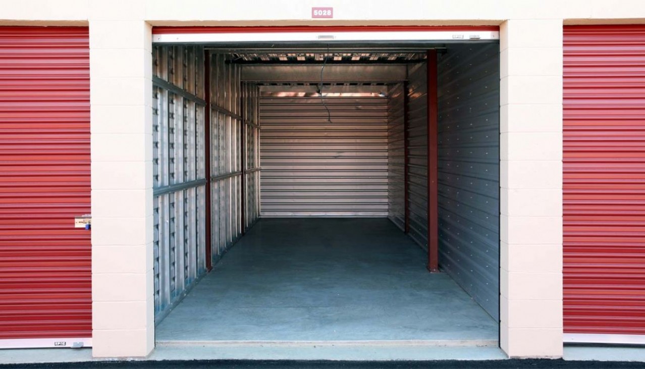 Large drive up storage unit with door rolled up and aluminum interior walls