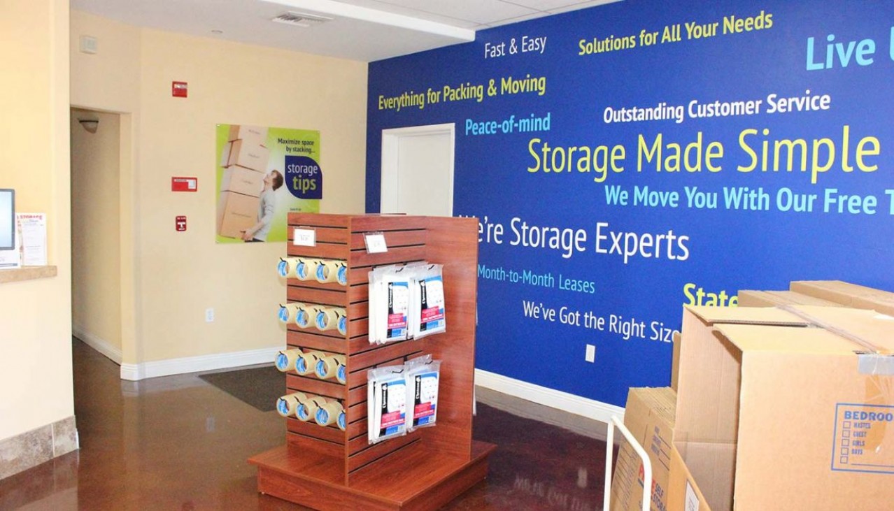 Rental office merchandise display rack and graphic wall behind