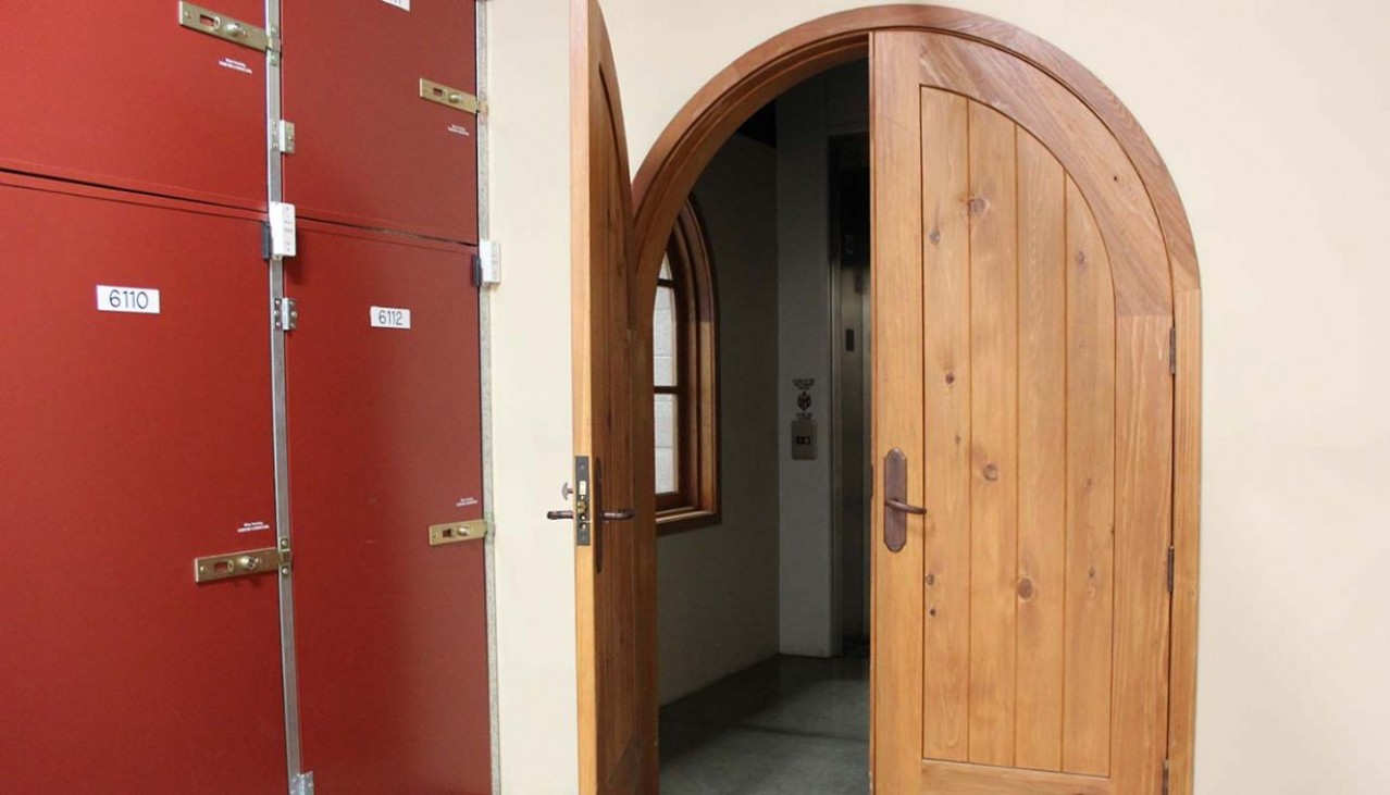 Wooden wine cellar arched door leading into the wine storage area of the facility