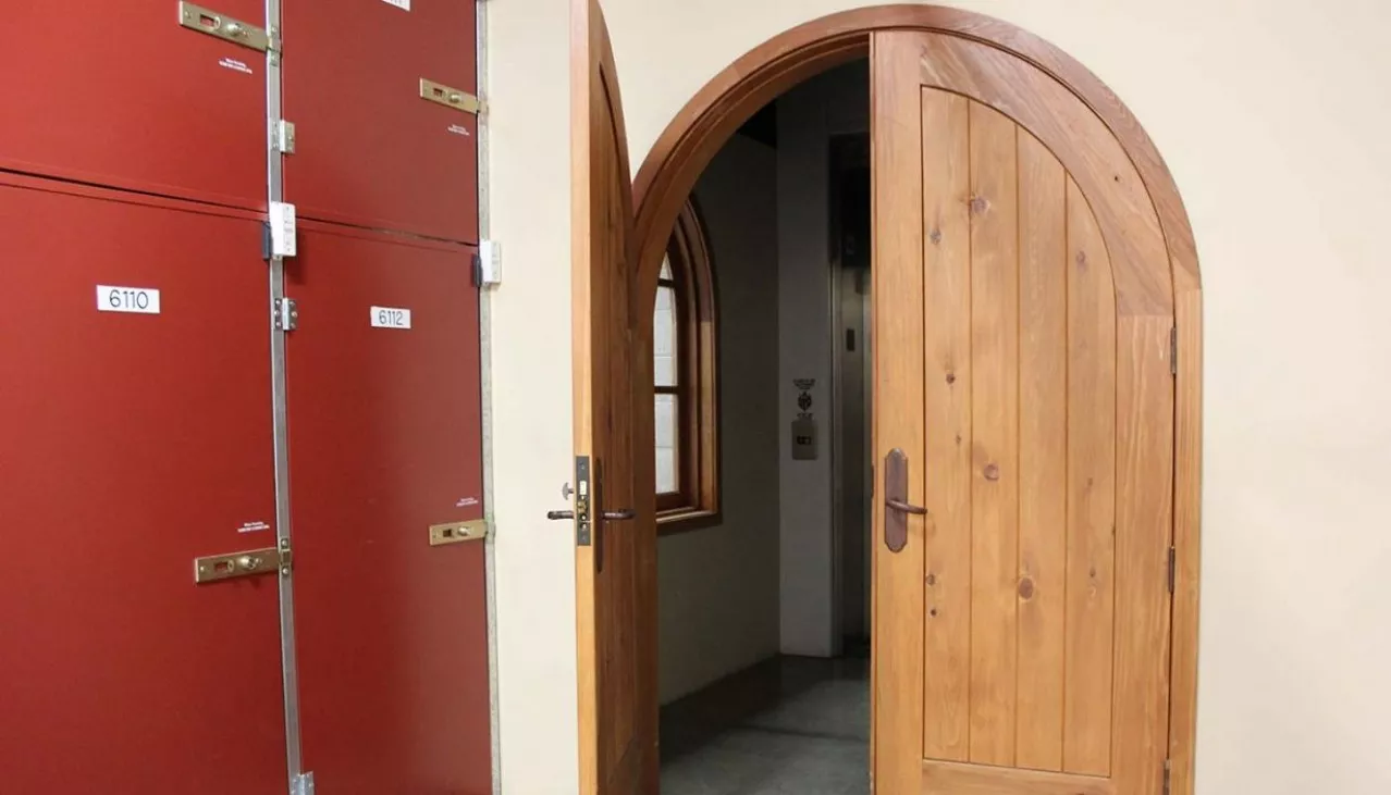 Wooden wine cellar arched door leading into the wine storage area of the facility